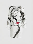 White mini dress with black and gray abstract face print, red lips, and V-neck, front view on gray background.