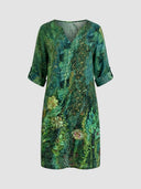Green floral mini dress with gold accents, V-neck, and rolled sleeves, front view.
