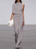 Gray sleeveless crew neck jumpsuit with wide legs, front view on a runway.
