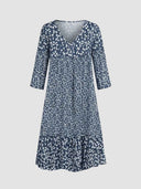 Navy blue mini dress with white floral print, V-neck, and tiered skirt, front view.