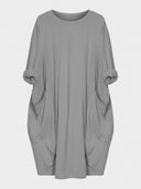Gray crewneck shirt dress with rolled sleeves and two large front pockets, front view.