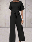 Black short-sleeve jumpsuit with a tied cinch belt, front view on a light background.
