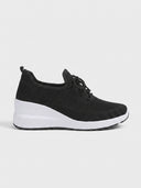 Black perforated knit lace-up trainer with white wedge cupsole, side view on white background.