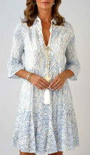 White and blue patterned mini dress with tiered skirt, front view.