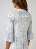 White and blue patterned mini dress with ruffled sleeves, back view.