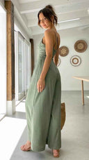 Green asymmetrical strapless jumpsuit with high waistline, angled back view.
