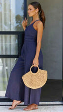 Navy asymmetrical strapless jumpsuit with high waistline, side view.