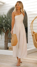 Beige asymmetrical strapless jumpsuit with high waist, front view.