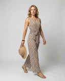 Tan patterned jumpsuit with V-neck, waist tie, and wide legs, front angled view on white background.