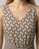 Beige jumpsuit with brown geometric pattern and V-neck, detail shot.