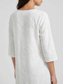 Amber Summer Mini Dress in White — back view showing all-over floral embroidered fabric and three-quarter sleeve detail.