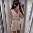 Beige sleeveless overall with lapel collar and brown belt, front view.