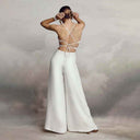 White backless jumpsuit with criss-cross straps and relaxed legs, back view.
