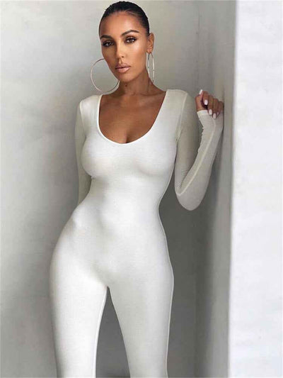 White seamless ribbed unitard jumpsuit with scoop neck and long sleeves, angled view against a white wall.