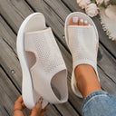 Beige mesh knit slip-on flatform sandals with breathable cut-out upper and white platform sole, angled side view.