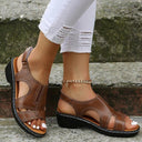 Brown cushioned wedge sandals with cutout upper detail and black contrast sole, angled side view.