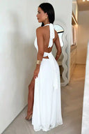 White maxi dress with halter neck and open back, side view.