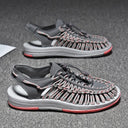 Gray and coral woven sandals with cushioned sole and heel strap, shown from side and angled views.