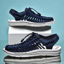 Navy blue unisex sandals with white cushioned sole and cord lacing, shown from side angles on white platform.