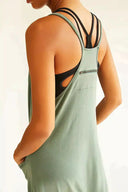 Sage green jumpsuit with black bra straps, angled back view on white background.