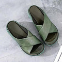 Sage green cross-strap platform sandals with chunky flatform sole, overhead view on concrete surface.