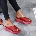 Red cross-strap platform sandals with chunky flatform sole, angled front view.