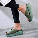 Sage green cross-strap platform sandals on feet, angled side view showing chunky flatform sole height.