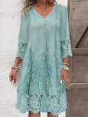 Teal V-neck mini dress with lace trim on sleeves and hem, front view.