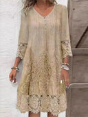 Tan mini dress with V-neck, button placket, lace trim, and embroidered details, front view.