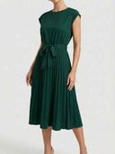 Dark green Ciara Pleated Cap Sleeve Midi Dress with self-tie bow belt, angled front view showing fully pleated A-line midi skirt, round neckline, and structured cap sleeves.