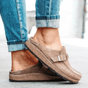 Khaki closed-toe platform mules with adjustable buckle strap and cork flatform sole, worn with rolled jeans, angled side view.