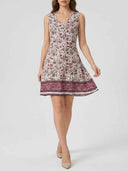 Cleo sleeveless floral mini dress, full-length front view showing all-over botanical print and deep berry contrast border hem.