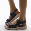 Coral cushioned arch support sandals in black with white contrast stitching, angled front view on neutral background.