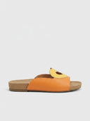Orange/red heart cutout flatform slide sandal with white heart appliqué on wide strap and cork footbed, side view.