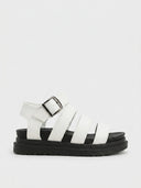 White chunky platform gladiator sandals with multi-strap toe cage, silver buckle ankle closure and black lug sole, side view on white background.