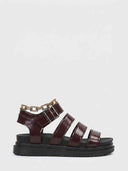 Wine red chunky platform gladiator sandals with three toe straps, gold chain ankle embellishment and silver buckle closure, side view on white background.