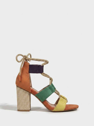 Side view of colourblock block heel sandals with woven raffia heel, rope ankle tie, and suede-look straps in terracotta, purple, teal and yellow-green on white background.