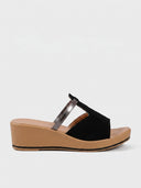Black cushioned wedge mule sandal with silver cross-strap accent and tan platform wedge sole, side view on white background.