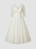 Daisy ivory floral appliqué V-neck midi dress with full A-line skirt and satin bow belt, front view on model.