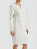 White cable-knit mini dress with long sleeves, split notch neckline, and straight silhouette — angled front view.
