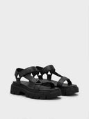 Black chunky platform sandals with grooved lug sole, angled view on white background.