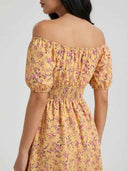 Daisy off-shoulder smocked floral mini dress showing elasticated bardot neckline and smocked waistband in yellow floral print, back view on white background.