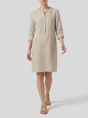 Daisy 3/4 sleeve shift dress in oat crisp-touch woven, front view showing patch pockets and button placket detail on model.