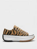 Tan animal-print platform trainers with black tiger stripes, chunky white ripple sole and tan laces, side view.