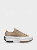 Tan suede-look platform trainers with chunky white ripple sole and jagged black and gum rubber outsole, side view.