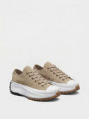 Tan suede-look low-top platform trainers with white chunky sole and brown tread, three-quarter angled view on white background.