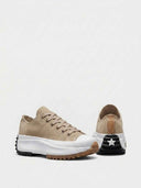 Tan suede-look platform trainer showing jagged black and brown ripple outsole and white midsole, angled view.