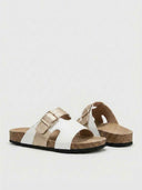 Adjustable double-strap leather flat sandals in white with champagne gold buckle strap, angled view on white background.