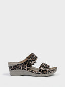 Leopard print two-strap wedge sandals with floral embellishments on upper straps, side view on white background.