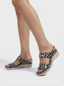 Leopard print two-strap wedge sandals with cushioned footbed, angled side view on white background.